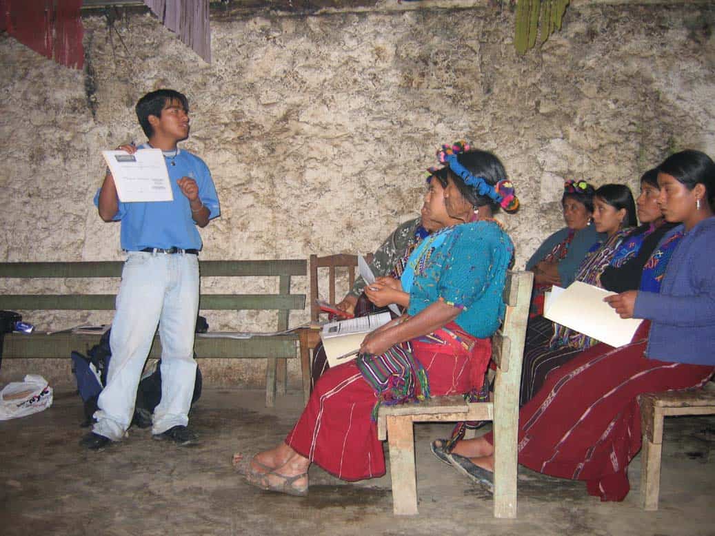 Ixil women attending a community educational session in traditional clothing.