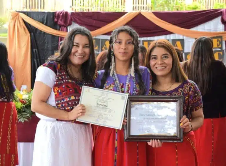 Three women celebrating graduation with certificates in Chajul, Guatemala.