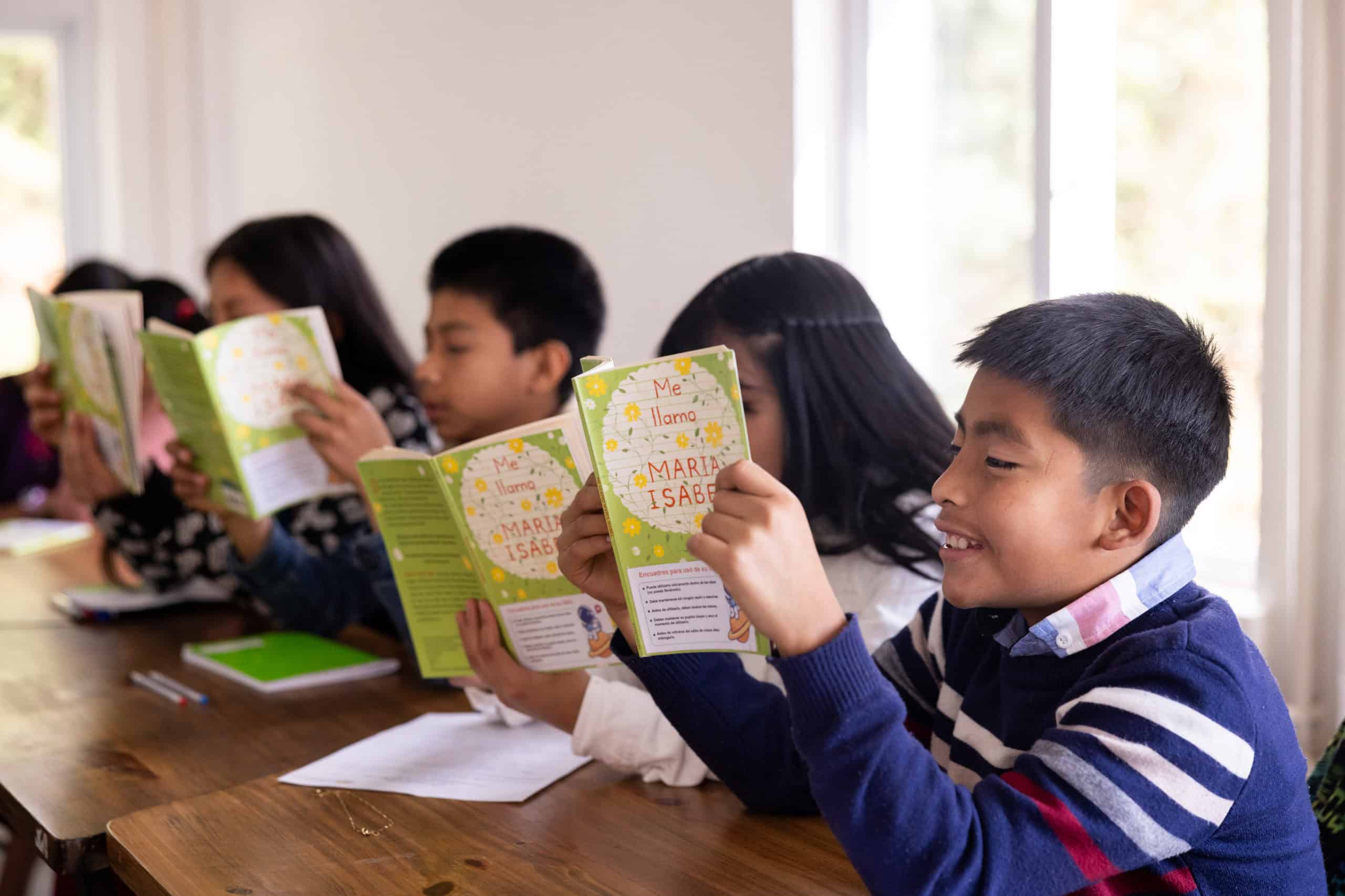 Young students reading books in a classroom at Colegio Horizontes.