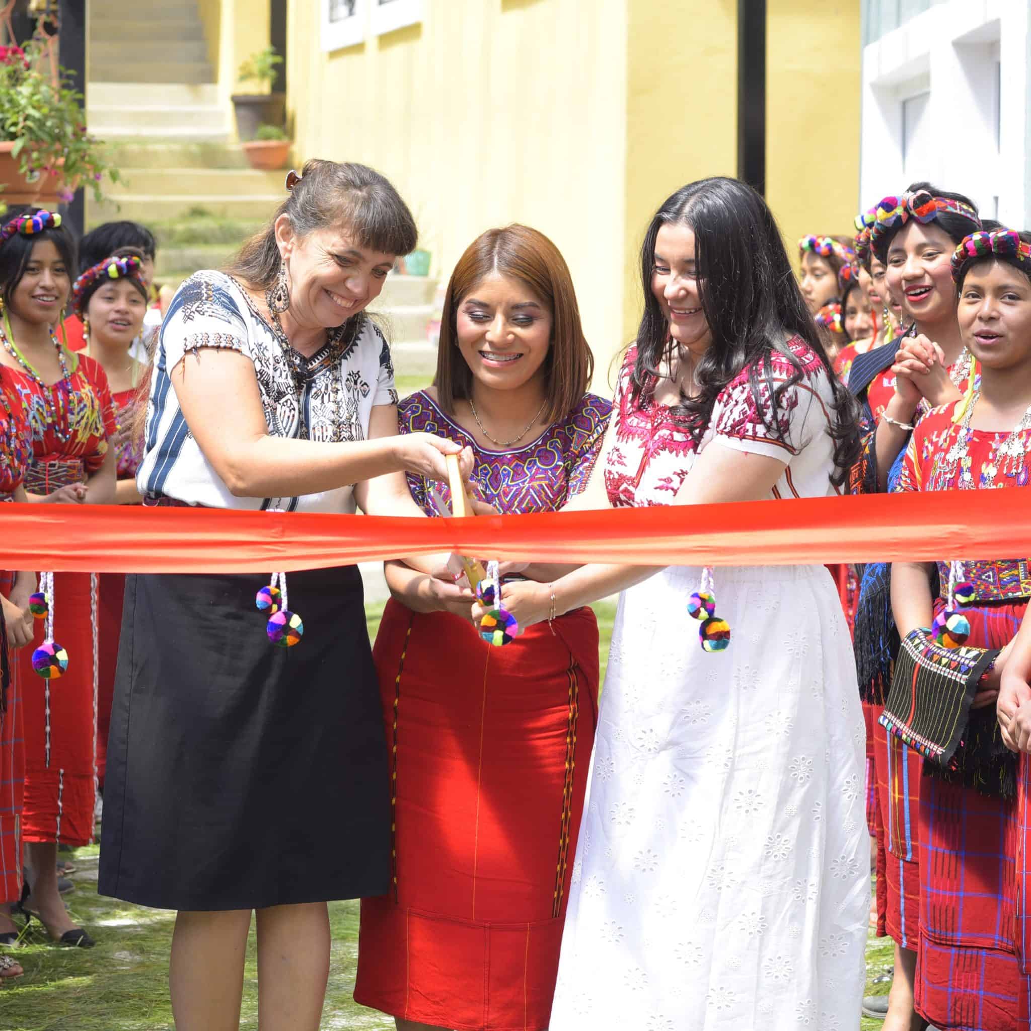 Women cutting ribbon at Limitless Horizons Ixil community event.