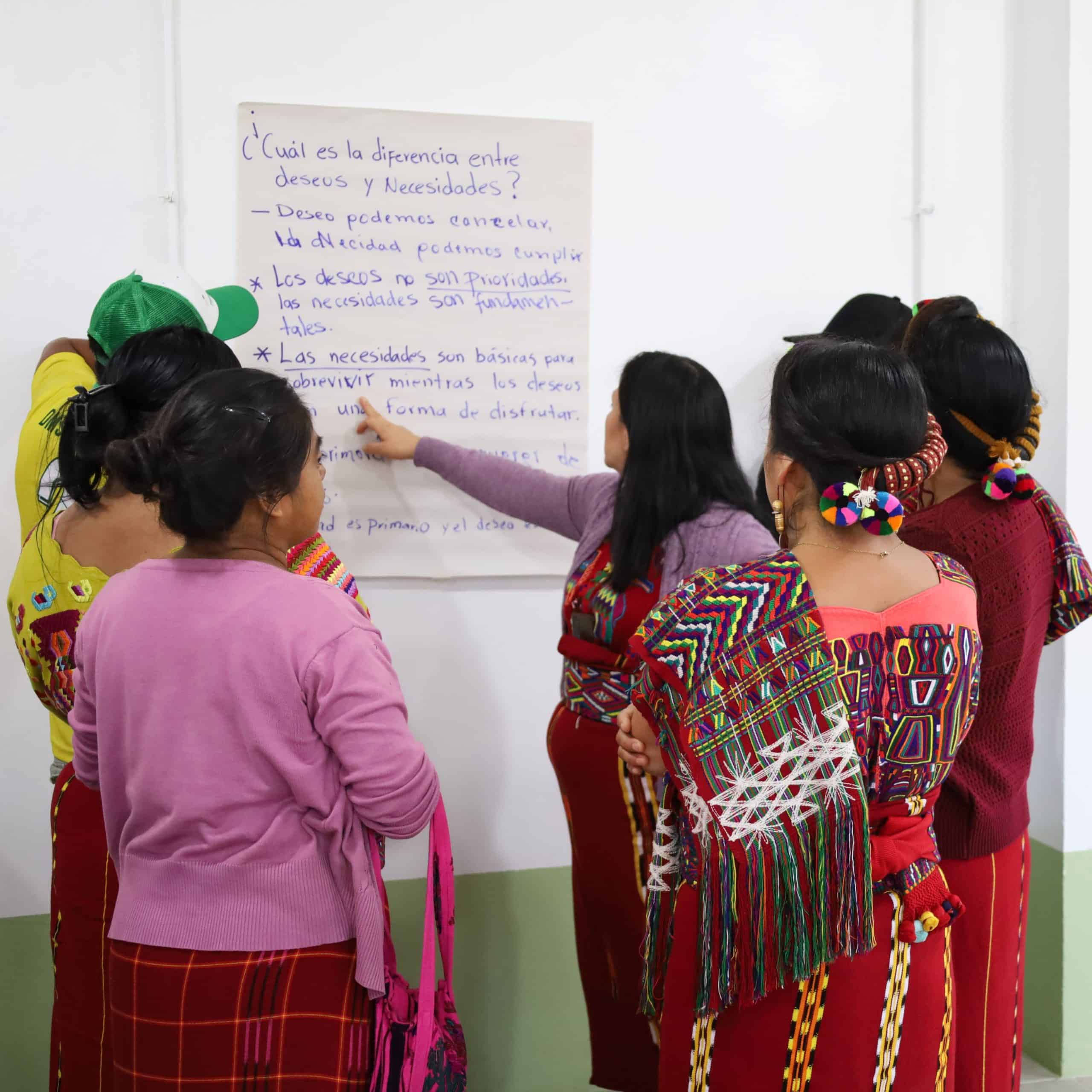 Women in traditional Ixil clothing participating in a classroom activity at Colegio Horizontes.