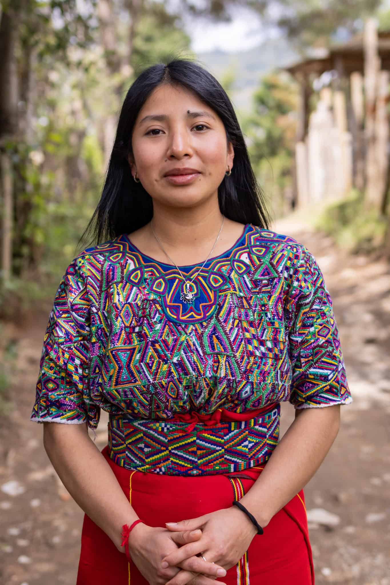 Lina Angélica de León Santiago in traditional Ixil attire outdoors.