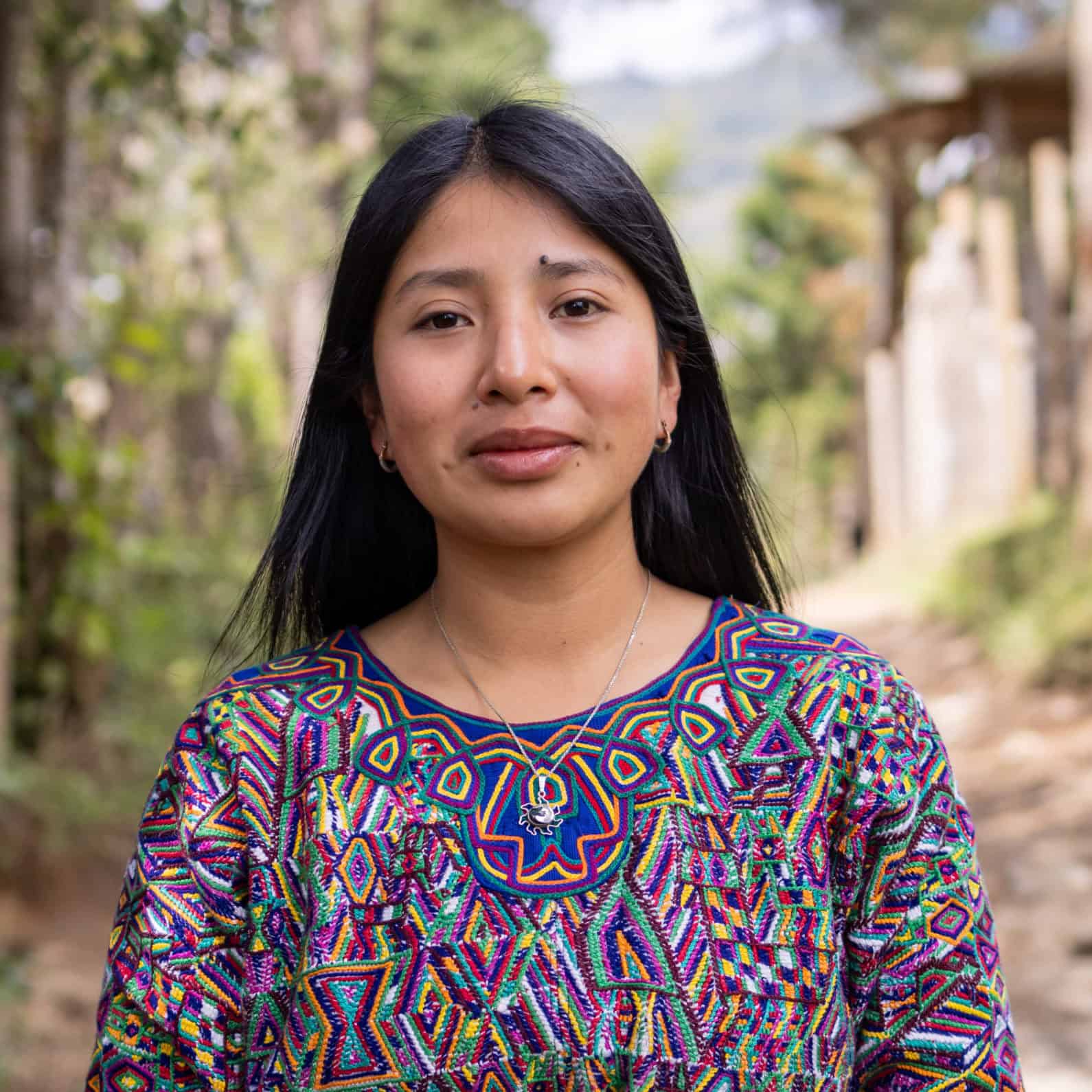 Lina Angélica de León Santiago in traditional Ixil attire outdoors.