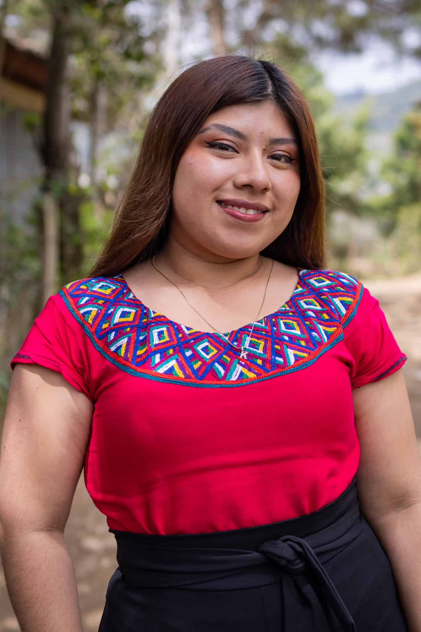 Portrait of Keyri Daniela Guevara López in traditional Ixil attire outdoors.