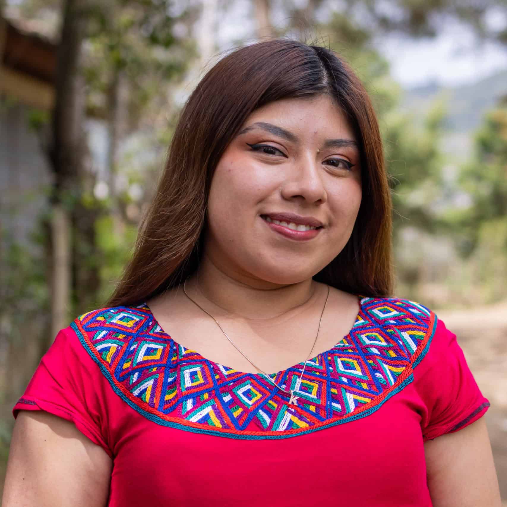 Portrait of Keyri Daniela Guevara López in traditional Ixil attire outdoors.