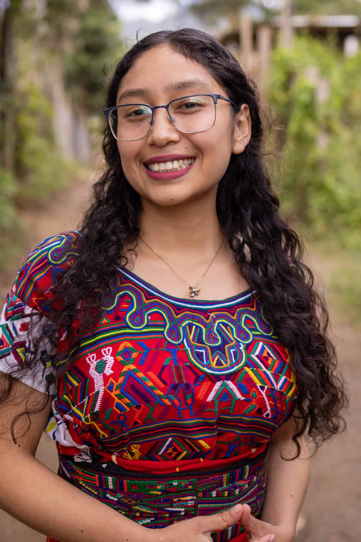 Portrait of Ana Nohemí Pérez Santiago, a young woman from Ixil community, smiling outdoors.