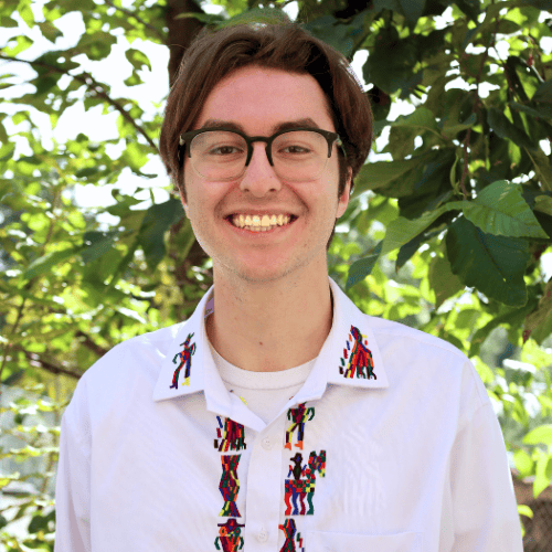 Staff member of Limitless Horizons Ixil smiling outdoors in a lush green setting.